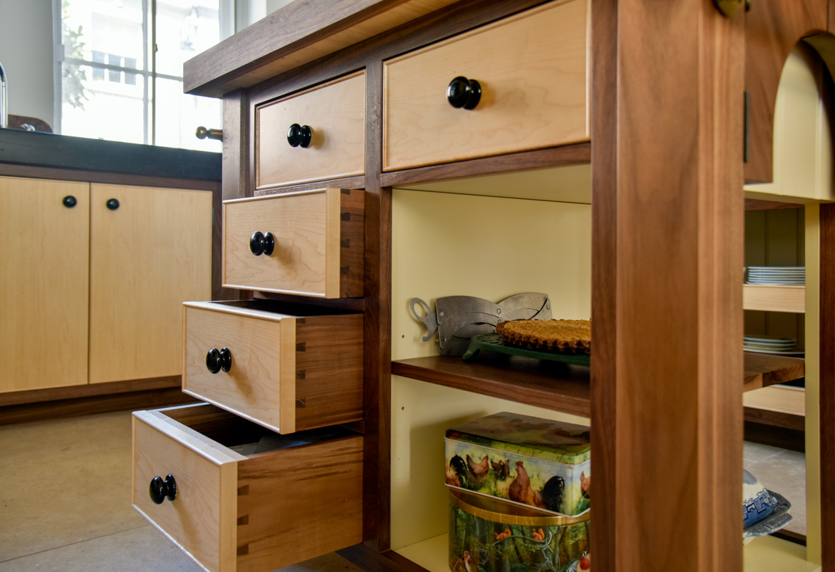 A two toned bespoke timber kitchen finished in a natural light and dark wood with a kitchen island in the centre 